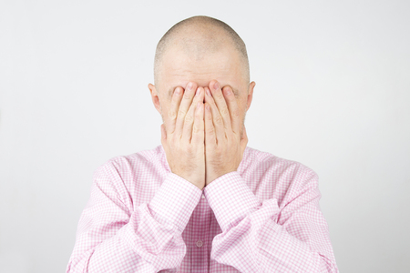 Man covers his face with his handsの写真素材