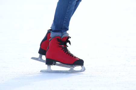 feet in red skates on an ice rinkの写真素材