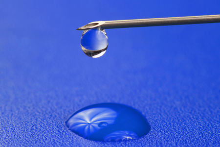 close-up of a drop of medicine on the tip of a medical injection needleの写真素材