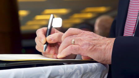 the hand of a business man signs an important document with a penの写真素材