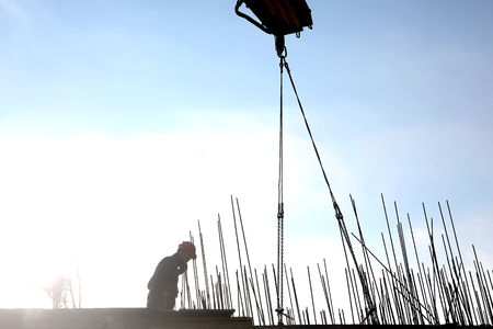 construction crane lifts the load against the sunの写真素材