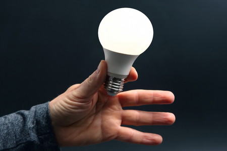 Included led new lamp in human hand on dark backgroundの写真素材