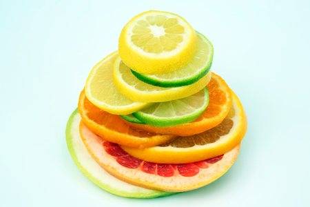 cut pieces of different citrus fruits on white backgroundの写真素材