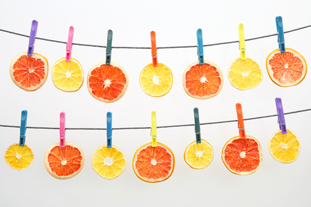dried pieces of citrus fruits hang on clothespinsの写真素材