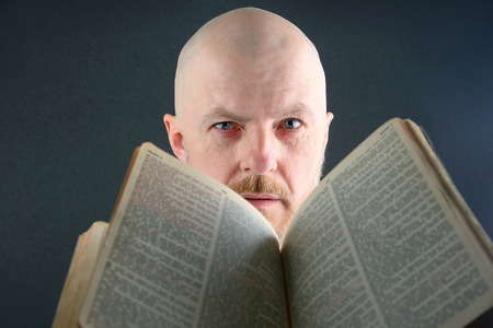 man looks through an open Bibleの写真素材