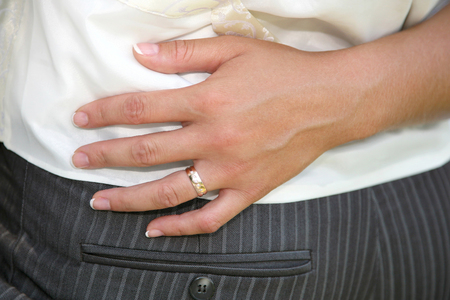 the hand of the bride hugged the groom waist. relationship of a married couple in loveの写真素材