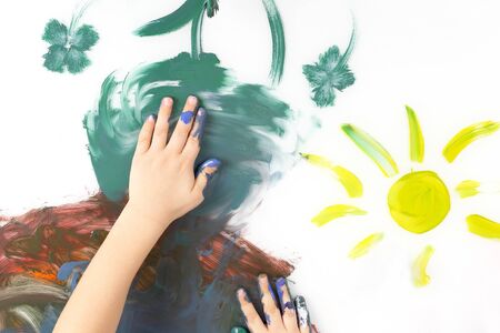 children hand paint a picture with paints on white background. children's creativity and Hobbiesの写真素材
