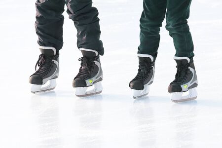 feet of different people skating on the ice rink. vacation sports and hobbiesの写真素材