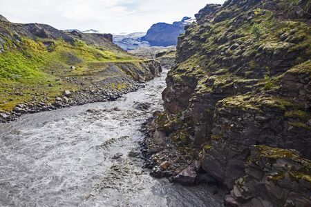 Stormy mountain river flows from glaciers in Icelandの写真素材