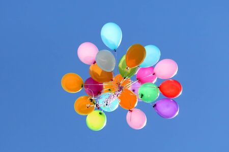 multicolored balloons flying in the blue sky. Holiday Decorations