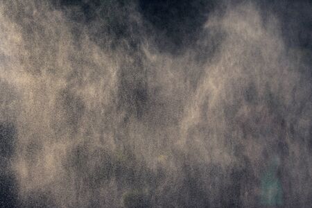 fog from a water fountain against the light of the sun