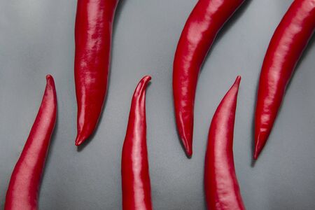 Spicy red fresh peppers on a gray background close-upの写真素材