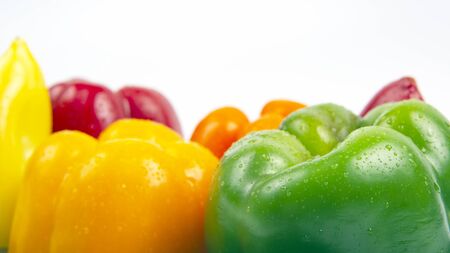 Fresh colored bell peppers on a white background. Vitamin wholesome food.の写真素材