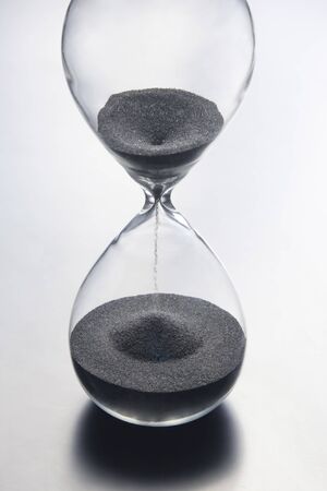 Hourglass on a light background. Time is money. Business solutions in time.の写真素材