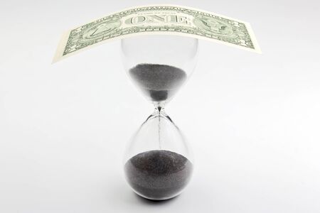 Dollar bill lies on the hourglass. Time is money. Salary. Business solutions in time.