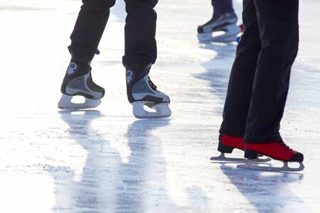 feet in skates on an ice rink. Sport and entertainment. Rest and winter holidays.の写真素材