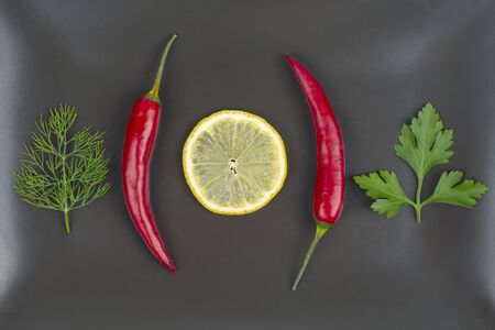 Fresh red hot peppers and lemon on a plate. Vitamin wholesome food.