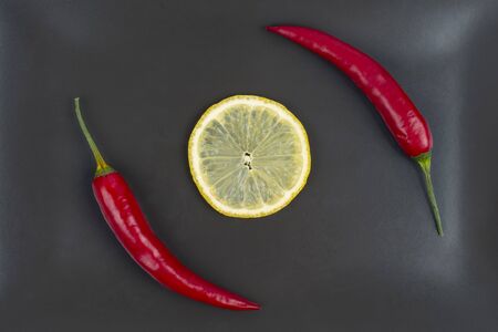 Red hot pepper with lemon on a gray plate. Healthy vegetable food and vitaminsの写真素材