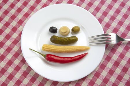 olives, pickled cucumber, red hot peppers, mushrooms and corn in a salad on a plate. food and vegetables. diet and weight lossの写真素材