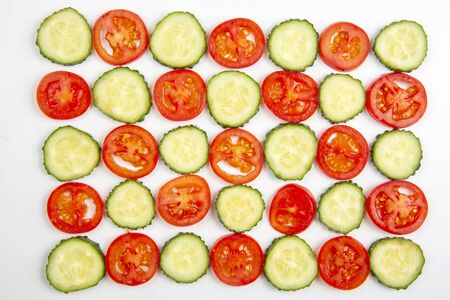 sliced ââpieces of cucumber and tomato on a white background. fast food and breakfastの写真素材