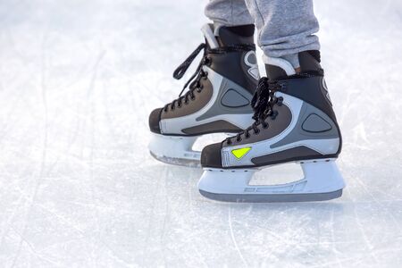 Legs of a man skating on an ice rink. Hobbies and sports. Vacations and winter activities.の写真素材