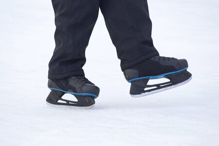 legs of a skating man on an ice rink. Hobbies and sports. Vacations and winter activities.