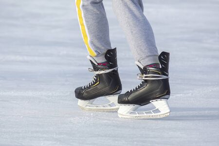 Legs of a man skating on an ice rink. Hobbies and sports. Vacations and winter activities.の写真素材