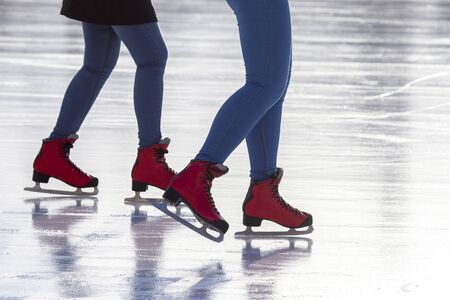 feet in red skates on an ice rink. Hobbies and sports. Vacations and winter の写真素材