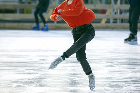 legs of a girl ice skating on an ice rink. Hobbies and sports. Vacations and winter activities.