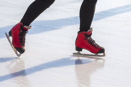 feet in red skates on an ice rink. hobbies and leisure. winter sportsの写真素材
