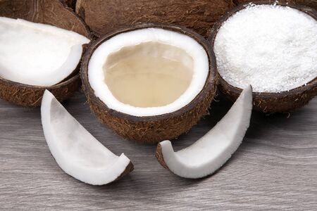 Sliced â€‹â€‹coconut with natural milk and coconut on a wooden board. Vitamin Fruits....