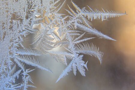 frosty patterns on the window glass closeup. natural textures and backgrounds. ice patterns on...