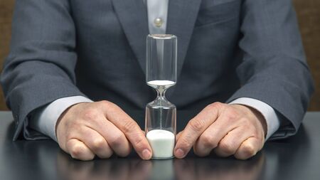 hourglass in the hand of a business man. distribution of time for work.
の写真素材