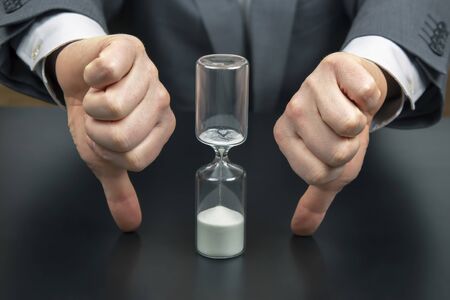 hourglass on the background of a business man. distribution of time for work. time to make decisions