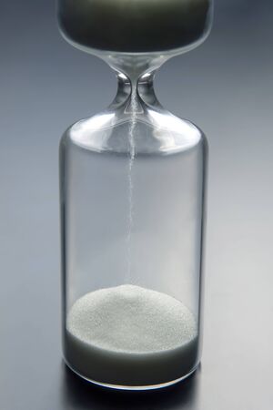 Hourglass on a light background. Time is money. Business solutions in time.