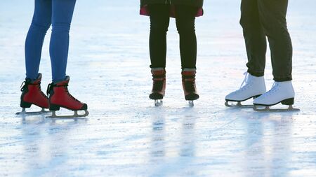 feet of different people skating on the ice rink. hobbies and leisure. winter sportsの写真素材