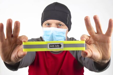 man in a medical mask and protective gloves holds a sign with the inscription sos info. virus quarantineの写真素材