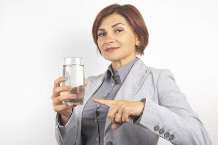 Happy beautiful business woman offers a glass of water. Thirst and health.の写真素材