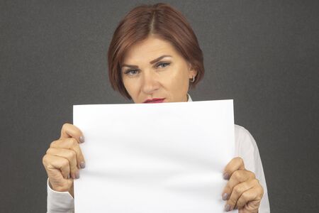 beautiful business woman holding a white sheet of paper in her handsの写真素材
