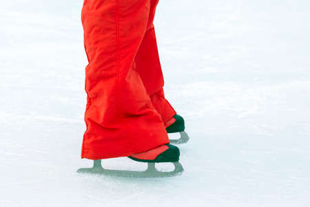 feet in red skates on an ice rink. hobbies and leisure. winter sportsの写真素材