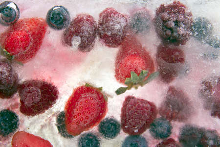 different juicy berries frozen in ice. useful vitamin healthy food fruitの写真素材