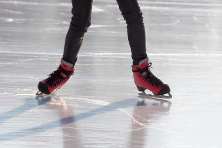 feet in red skates on an ice rink. hobbies and leisure. winter sportsの写真素材