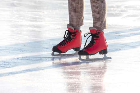 feet in red skates on an ice rink. hobbies and leisure. winter sports