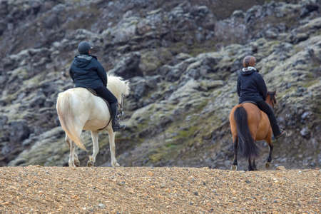 the rider rides on an Icelandic horse against a mountain landscape