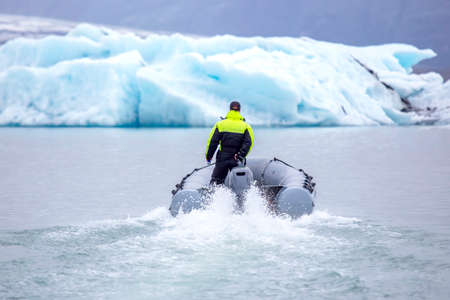 man on a fast motor boat sailing on a glacier lagoon in Iceland