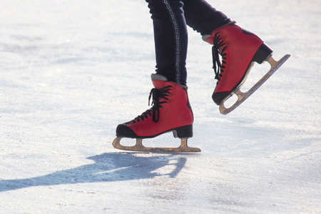 feet on the skates of a person rolling on the ice rinkの写真素材