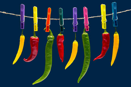 peppers hanging on clothespins. Vegetable vitamin food. Colored hot chili