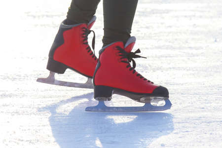 feet in red skates on an ice rink. hobbies and leisure. winter sportsの写真素材