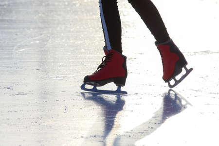 feet in red skates on an ice rink. hobbies and leisure. winter sportsの写真素材