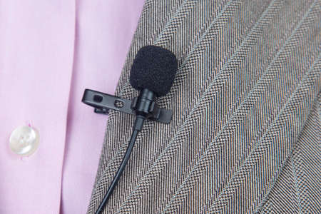 clip-on lavalier microphone is attached to women's clothing close-up. Audio recording of the sound of the voice on a condenser microphone.の写真素材